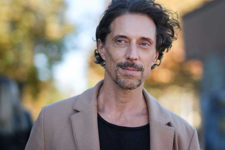 Headshot eines Schauspielers mit freundlichem Bick und Herbstfarben im Hintergrund